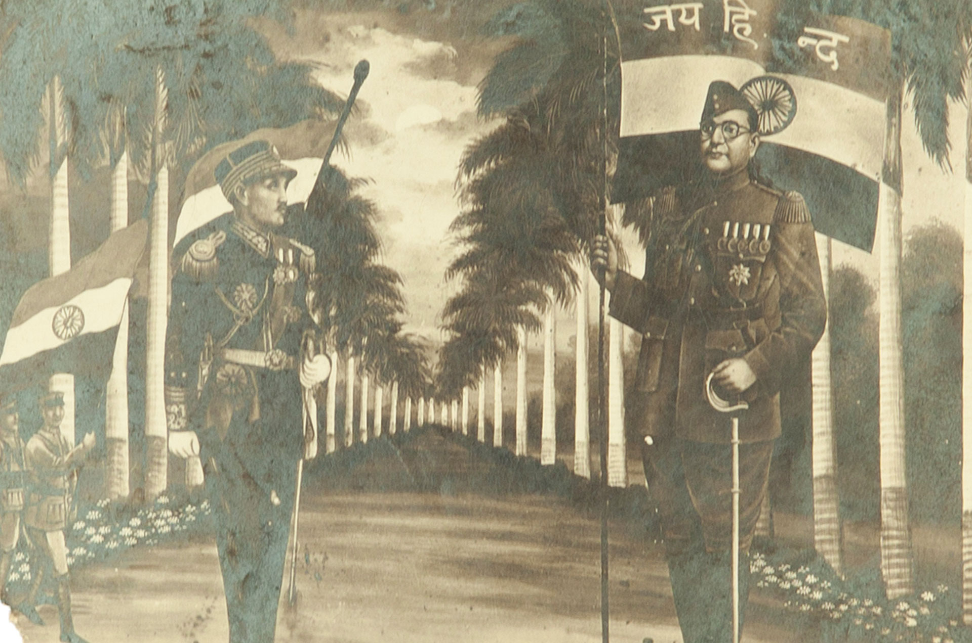On the right is Subhas Chandra Bose holding the Indian flag. Opposite him, a soldier in dress uniform stands with the flag seen behind his head. They stand in between two long rows of trees. There are two soldiers in the background bottom left corner, one of whom holds a flag as well.