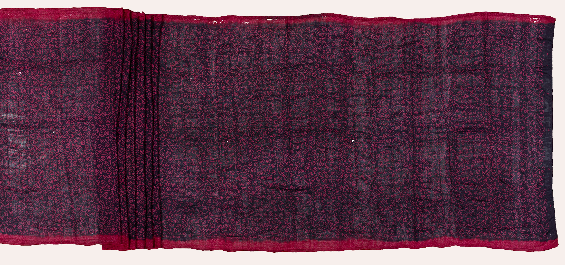 A rectangular cloth with a few pleats at the center and a pink border at the smaller and larger ends. Magnified detail of the cloth before this was derived from here.