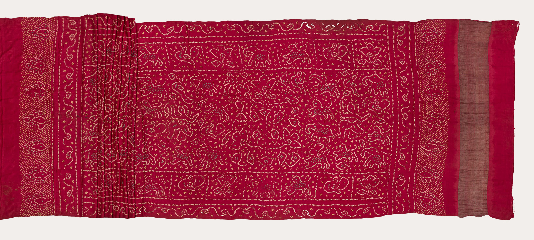 A rectangular red textile with some pleats at the center.