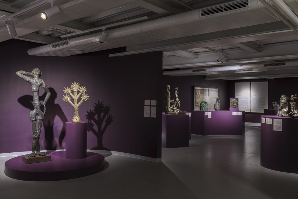 Dhokra sculptures in front of a purple background